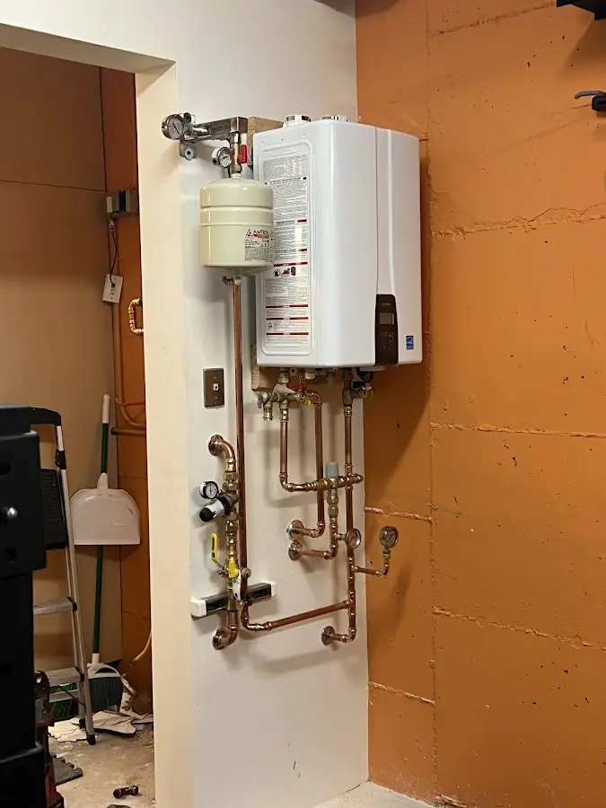 Plumbing technician inspecting water heater connections in Pine Castle